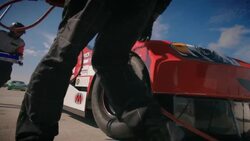 Stock car driver pulls into pit-road, pit-crew leaps into action, jacks race-car and removes lug-nuts Stock Footage