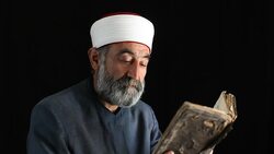 Senior muslim imam reading in dark Stock Footage
