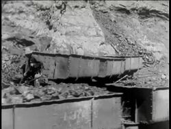 1938 B/W MONTAGE LS Coal mine, men drill and steamshovel scoops coal and loads into train car, iron mine with large grinding machines with iron ore, smelting furnances, molten metal, rolling mill makes wire and steel girders / Manchuria
 Stock Footage