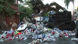 A bulldozer scoops all kinds of trash from a street in New Orleans. Stock Footage
