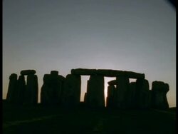 T/L Dusk Sun and Stonehenge - Sun setting behind silhouetted stone circle Stock Footage