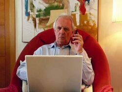 MS Shot of senior male on phone with laptop / Spain Stock Footage