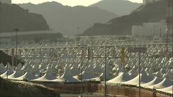 A breeze blows plants near tent pavilions with pointed peaks in a mountainous region of Saudi Arabia. Stock Footage
