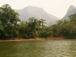 MS POV SLO MO Shot of tree lined river bank and mountains / Ou river, Luang Prabang, Laos Stock Footage