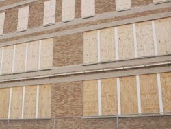 WS PAN Boarded up windows at abandoned elementary school Stock Footage