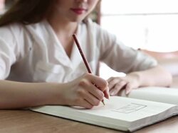 Chinese female student writing on notebook in library,real time. Stock Footage