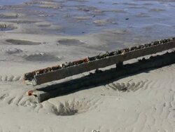 Rusted Metal Railway Track Lying on a Deserted Beach Stock Footage