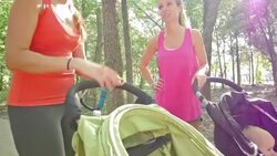 Mothers talking after exercising in park with jogging strollers Stock Footage