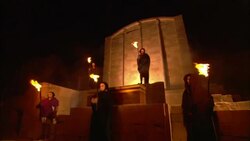 Monks wave flaming torches as they stand outside a temple. Stock Footage