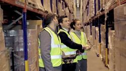 Supervisor and workers taking inventory in distribution warehouse Stock Footage