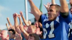 Anxious stadium crowd cheers at football game, jumps to feet Stock Footage