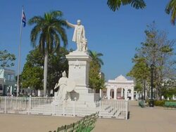 MS shot of trinidad cuba main square with statue of jose marti and cuban flag blowing / Trinidad, Cuba Stock Footage