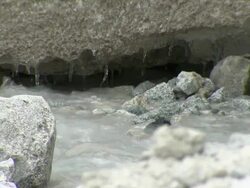 CU of ice formation dripping into small stream on Huayna Potosi glacier in Andes region of Bolivia Stock Footage