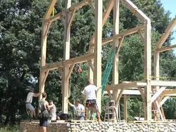 WS ZO Carpenters and crane operator slowly moving part of structure into place during framing of an energy efficient post / Grass Lake, Michigan, USA  Stock Footage