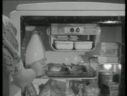 Housewife puts milk bottle in fridge and takes plate out, UK  1939 Stock Footage