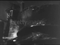 1944: STEEL MILL: WS Steel mill, smoke stacks. VS Large ladles & carts full of scrap metal moving into factory. INT VS Crane arm dumping materials into blast furnace. Foundry, steelworks, metals, parts Instructional Video