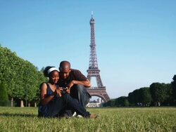 couple looking at their photos in front of the Eiffel tower Stock Footage