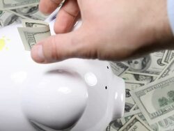 Hand pulling out money from piggy bank Stock Footage