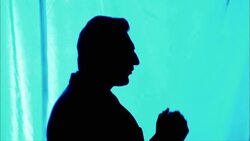 A man gestures with his hands as he speaks while standing in silhouette. Stock Footage