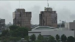 Abidjan skyline, gunfire, smoke, troops on streets News Clip