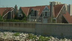 Levee walls separate a canal from nearby homes. Stock Footage