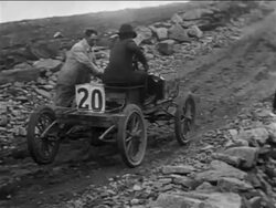 B/W 1905 man pushing race car up hill in car race on Pike's Peak / documentary Stock Footage