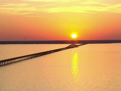 WS AERIAL View of Sunset over Colington Island shore with bridge on lake / North Carolina, United States Stock Footage