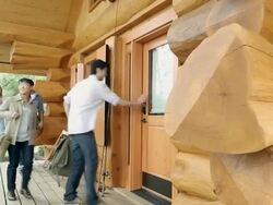 Young people arriving at log cabin Stock Footage