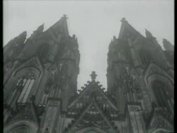 June 23, 1963 FILM MONTAGE MS John F. Kennedy arriving at Cologne Cathedral/ WS Crowd of press people/ MS TD Cologne Cathedral/ MS Kennedy meeting dignitaries/  MS Kennedy standing in car with Chancellor Konrad Adenauer  / Cologne, Germany Stock Footage