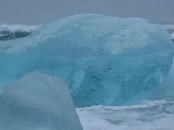 CU Ocean wave rolling in to washed glaciers on Jokulsa Iceberg Beach at mouth of Jokulsarlon / Iceland Stock Footage