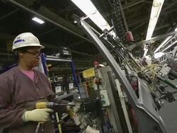 MS Woman preparing door for installation on minivan in an auto assembly plant / Princeton, Indiana, United States Stock Footage