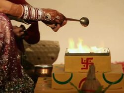 Bride and groom pouring ghee into havan kund  Stock Footage