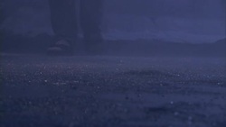 A person in jeans, socks and sandals slowly walks across slush. Stock Footage