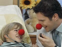 HD DOLLY: Clown Doctor Entertaining A Sick Child Stock Footage