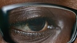 ECU African-American brown eye looking through glasses Stock Footage