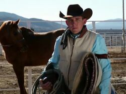 MS Cowboy stands infront of horse holding saddle and saddle blanket / Kirkland, Arizon, USA Stock Footage