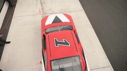 Red race-car pulls into pit-road, pit-crew leaps into action Stock Footage