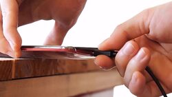 man plugging charging cable into mobile phone on white background Stock Footage