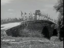 1944: NATIONALIST YOUTH: San Min Chu I Youth Corps in uniform, marching w/ Nationalist flags, marching over bridge, w/ shirts off working in wheat field, carrying wheat on shoulder poles, thrashing wheat by hand. (not Communist) Instructional Video