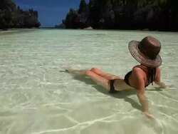 WS, beautiful caucasian woman wearing sun hat relaxing in tropical waters in secluded lagoon / Matinloc Island, Bacuit Archipelago, El Nido, Palawan, Philippines Stock Footage