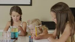Medium panning shot of girls experimenting with mixing liquids / Orem, Utah, United States Stock Footage