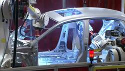 Robotic arms weld parts in an auto factory. Stock Footage
