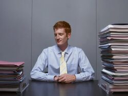 Time lapse office worker watching folders stack up between In and Out bins/ smiling at CAM between empty bins Stock Footage