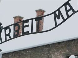 CU PAN Shot of  main entrance gate of Auschwitz with snow rain / Auschwitz-Birkenau, Krakow, Poland Stock Footage