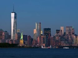 T/L View of the Statue of Liberty and the One World Trade Center as seen from across the Hudson River at dusk Stock Footage