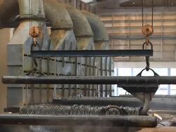 Steel Mill - Coils lifted from bath Stock Footage