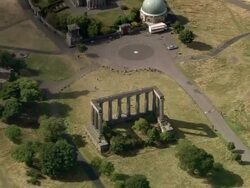 Aerial tourists visiting National Monument / zoom out view of Calton Hill east of central Edinburgh Stock Footage