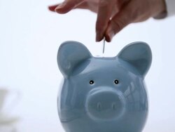 Coins being placed in blue piggy bank, one by one. Stock Footage