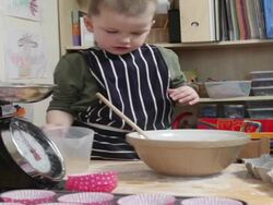Two young boys making cakes together on kitchen table full of excitement  Stock Footage