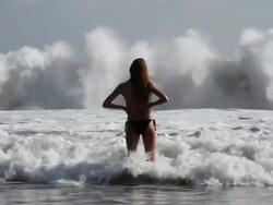 MS SLO MO Shot of Teenage girl standing in sea waves / Seminyak, Bali, Indonesia Stock Footage